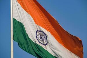 India flag flying high at Connaught Place with pride in blue sky, India flag fluttering, Indian Flag on Independence Day and Republic Day of India, tilt up shot, Waving Indian flag, Har Ghar Tiranga photo