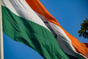 India flag flying high at Connaught Place with pride in blue sky, India flag fluttering, Indian Flag on Independence Day and Republic Day of India, tilt up shot, Waving Indian flag, Har Ghar Tiranga photo