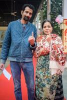 Delhi, India - July 04 2023 - Unidentified people showing their ink-marked fingers after casting votes in front of polling booth of east Delhi area for MCD local body Elections 2022 photo