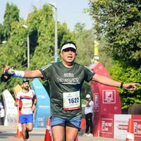 nuevo Delhi, India - junio dieciséis 2023 - vedanta Delhi medio maratón carrera después codicioso en cuales maratón Participantes acerca de a cruzar el terminar línea, Delhi medio maratón 2022 foto