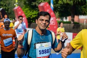 nuevo Delhi, India - junio dieciséis 2023 - vedanta Delhi medio maratón carrera después codicioso en cuales maratón Participantes acerca de a cruzar el terminar línea, Delhi medio maratón 2022 foto