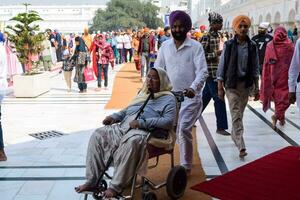 Amritsar, India - February 26 2023 - Unidentified devotees from various parts at Golden Temple Harmandir Sahib in Amritsar, Punjab, India, Famous indian sikh landmark, Golden Temple photo