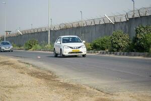 New Delhi, India - April 16, 2023 - View of Vehicles passing through the main road near Indra Gandhi International Airport Delhi at Dwarka link road photo