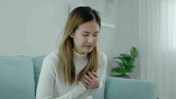 hand hold chest with heart attack symptoms, asian woman working hard have chest pain caused by heart disease, leak, dilatation, enlarged coronary heart, press on the chest with painful expression video