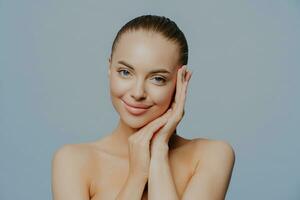 Beauty face portrait. Spa model with fresh, clean skin. Blue background. Brunette looking at camera. Youth, skin care concept. photo