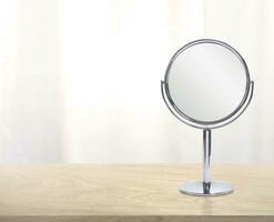 Round mirror on wooden table photo