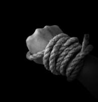 Man's hand holding on to the rope. Hand holding a rope photo