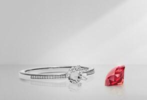 White gold or silver ring without gemstone and round red diamond with reflection on a background photo