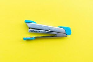 A stapler isolated on yellow background, after some edits. photo