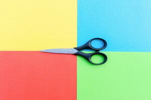 Scissors placed on colored papers, after some edits. photo