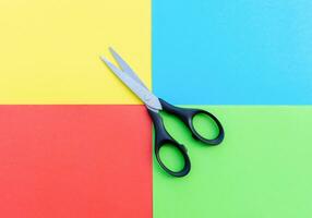 Scissors placed on colored papers, after some edits. photo