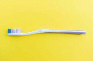 A toothbrush isolated on yellow background, after some edits. photo