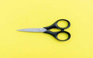 Scissors isolated on yellow  background, after some edits. photo