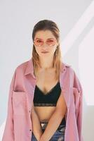 Portrait of young beautiful caucasian woman in dirty pink jacket and eye wear Natural beauty, fashioni photo