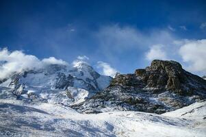 Panoramic view of towering mountains of Gornergrat covered with snow and clouds on a clear day. It is an image that shows the beauty of great nature suitable to attract tourists to visit uninterrupted photo