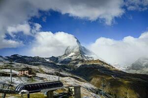 Beautiful view of the Matterhorn peak, Switzerland surrounded by amenities such as accommodation, cable car that support tourist along year. photo