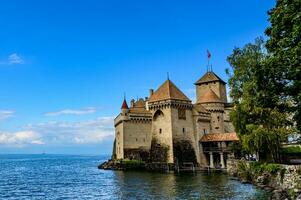 Beautiful old gothic style castle by the lake in blue sky. One of the classic castles is the Chateau De Chillo of Montruex built around the thirteenth century along Lake Geneva, Switzerland, photo