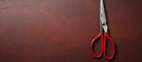 Photo of a pair of red scissors on a table with empty space for text or design with copy space