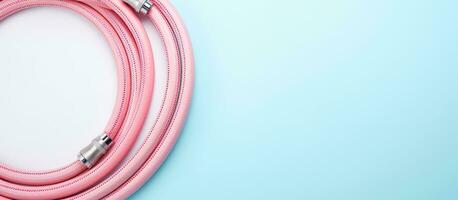Photo of a close up of a vibrant pink cord against a contrasting blue background with plenty of copy space with copy space