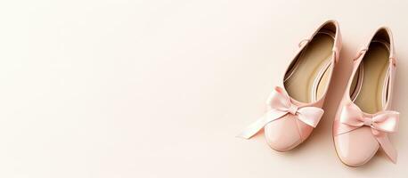 Photo of a pair of pink ballet shoes with a delicate bow, perfect for any aspiring ballerina with copy space