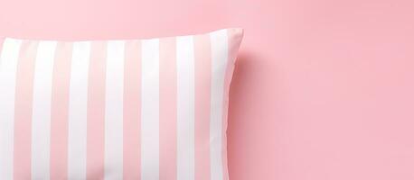 Photo of a pink and white striped pillow against a soft pink background with copy space