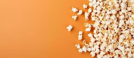 Photo of a pile of popcorn on a vibrant orange background with plenty of copy space with copy space