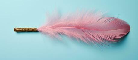 Photo of a vibrant pink feather with a shimmering gold tip against a captivating blue backdrop with copy space