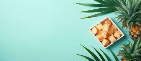 Photo of pineapple slices and a whole pineapple on a vibrant blue background with copy space