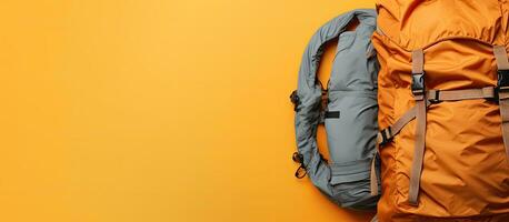 Photo of a backpack on a vibrant yellow wall with empty space for text or design with copy space