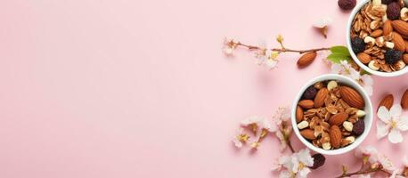 Photo of two bowls of nuts and almonds on a pink background with copy space with copy space