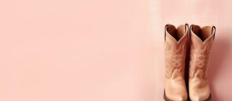 Photo of a pair of cowboy boots hanging on a pink wall with copy space