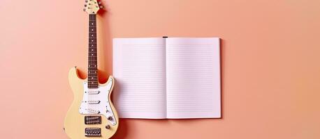 Photo of a guitar and a notebook on a vibrant pink background with plenty of copy space with copy space