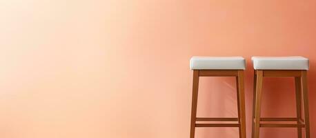 Photo of two wooden stools against a pink wall with empty space for copy with copy space