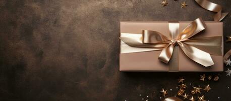 Photo of a beautifully wrapped gift box with a golden ribbon and sparkling stars with copy space