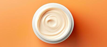 Photo of a cup of yogurt on a vibrant orange background with ample copy space with copy space