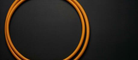 Photo of an orange cord on a black surface with empty space for text or other elements with copy space