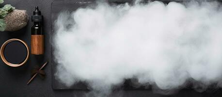 Photo of a black table with a mesmerizing white cloud of smoke with copy space