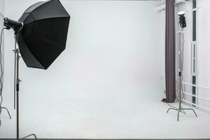 interior of bright space of photo studio with large white cyclorama with lighting equipment