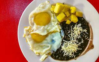 Mexican omelet eggs black beans potatoes nachos on white plate. photo