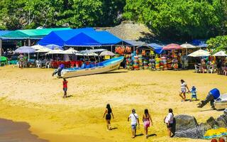 Puerto Escondido Oaxaca Mexico 2023 Palms parasols sun loungers beach people Zicatela Puerto Escondido Mexico. photo