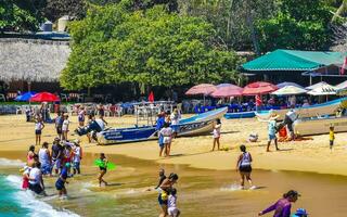 Puerto Escondido Oaxaca Mexico 2023 Palms parasols sun loungers beach people Zicatela Puerto Escondido Mexico. photo