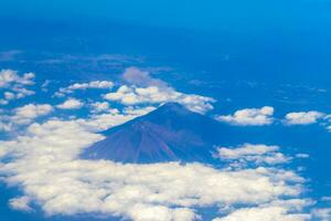 Flying by plane over Mexico view of volcanoes mountains clouds. photo