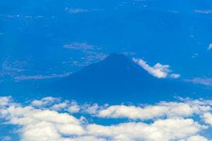 Flying by plane over Mexico view of volcanoes mountains clouds. photo