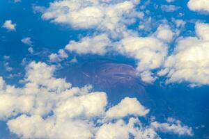 Flying by plane over Mexico view of volcanoes mountains clouds. photo