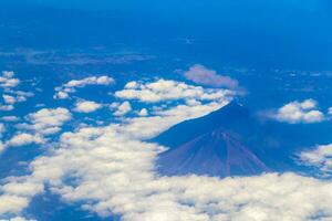 Flying by plane over Mexico view of volcanoes mountains clouds. photo