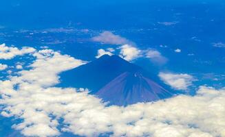 Flying by plane over Mexico view of volcanoes mountains clouds. photo