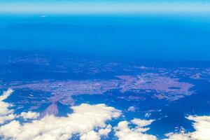 Flying by plane over Mexico view of volcanoes mountains clouds. photo