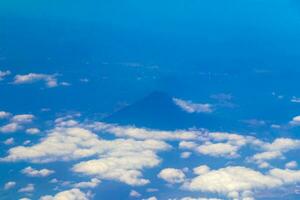 Flying by plane over Mexico view of volcanoes mountains clouds. photo