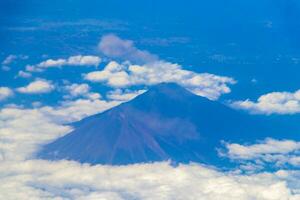 Flying by plane over Mexico view of volcanoes mountains clouds. photo