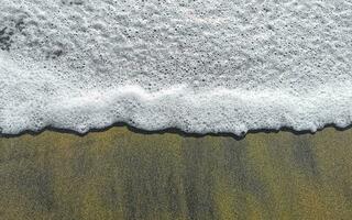 Wet beach sand water and waves texture and pattern in Mexico. photo